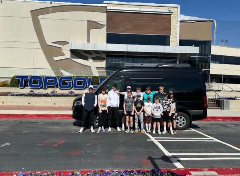 A team posing with the Sprinter outside Topgolf